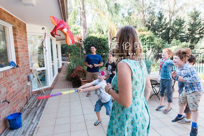 Kids batting at a piñata from a Jurassic Park Dinosaur Birthday Party via Kara